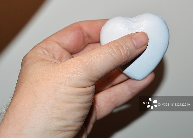 手持锡纸包装的巧克力心形图片素材