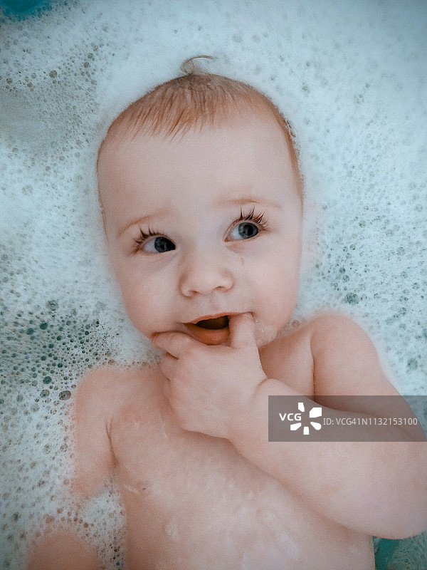 在浴缸里微笑的新生婴儿图片素材