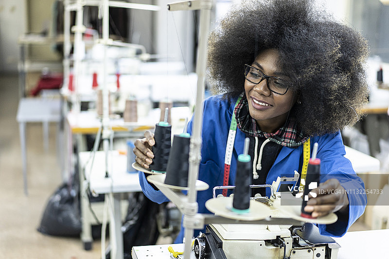 在缝纫工作室工作的年轻非裔女子图片素材