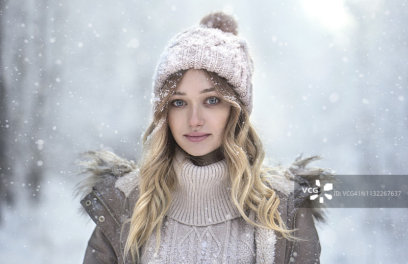 雪中戴羊毛帽的年轻女人肖像图片素材