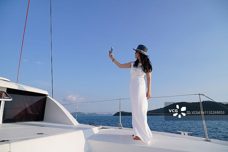 一位女士在游艇上自拍，庆祝成功人生图片素材