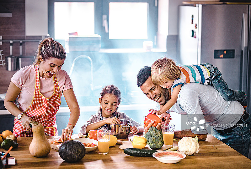 幸福的家庭在厨房里准备健康膳食图片素材