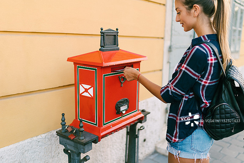 在公共邮箱里寄信的游客图片素材