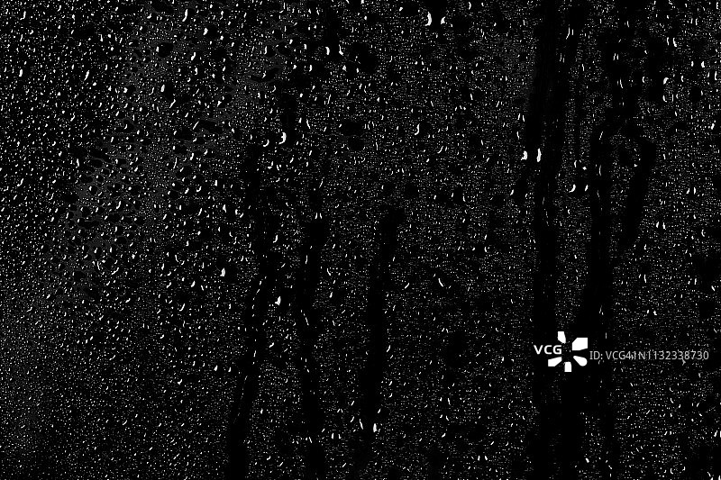 深色玻璃纹理背景上的水滴图片素材