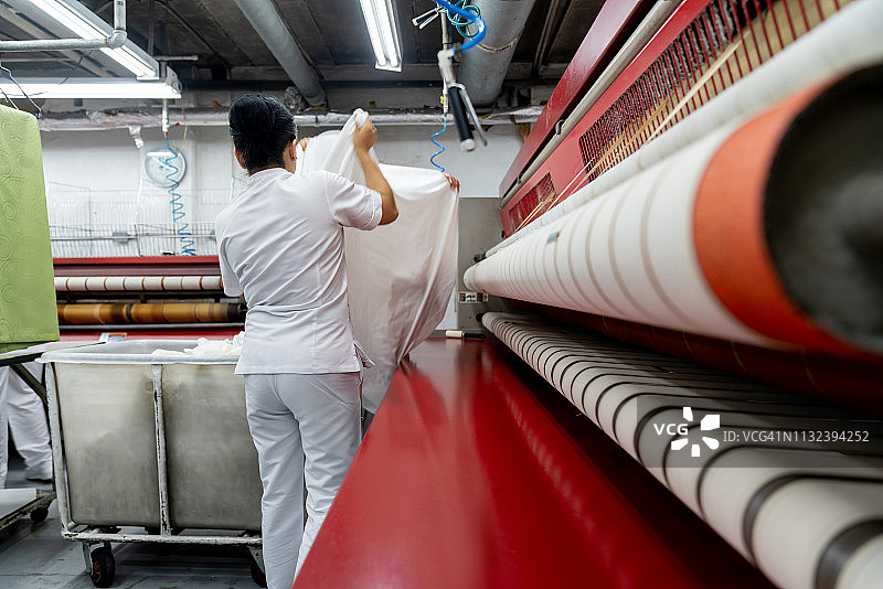 妇女团队在洗衣店熨烫床单图片素材