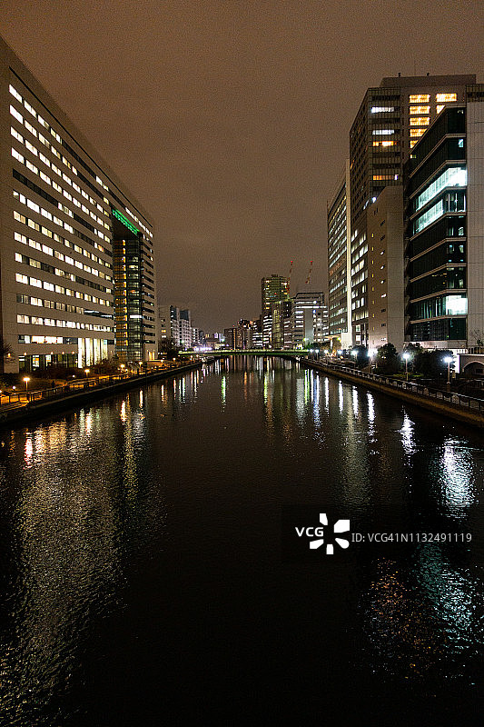 日本东京港区高滨运河上反射的照明办公和住宅楼图片素材
