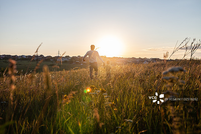 匿名父子在田野里散步图片素材