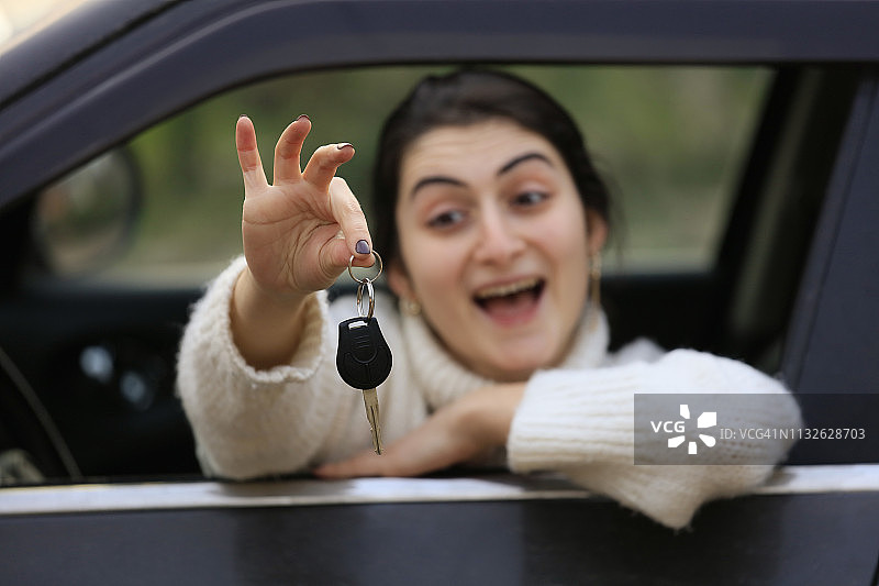 坐在车里拿着钥匙的女人图片素材