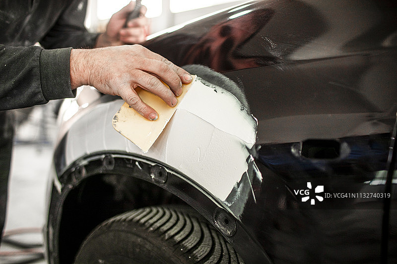 使用汽车腻子修复事故车零件图片素材