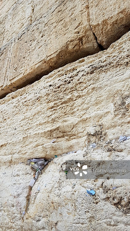 低角度拍摄的西墙特写，墙缝里塞满了纸条图片素材