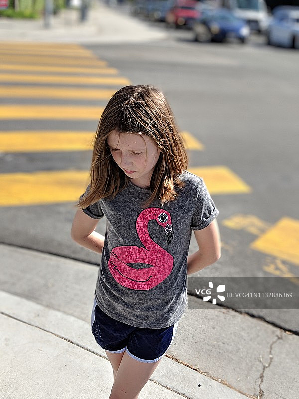 女孩在人行横道上悲伤地看着图片素材