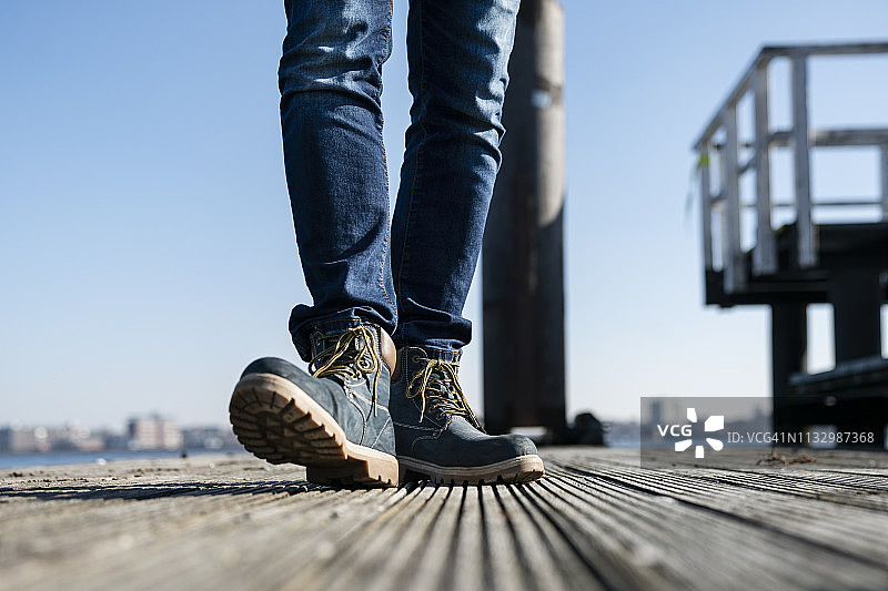 在德国阳光明媚的一天，男子走在码头上的下半身图片素材