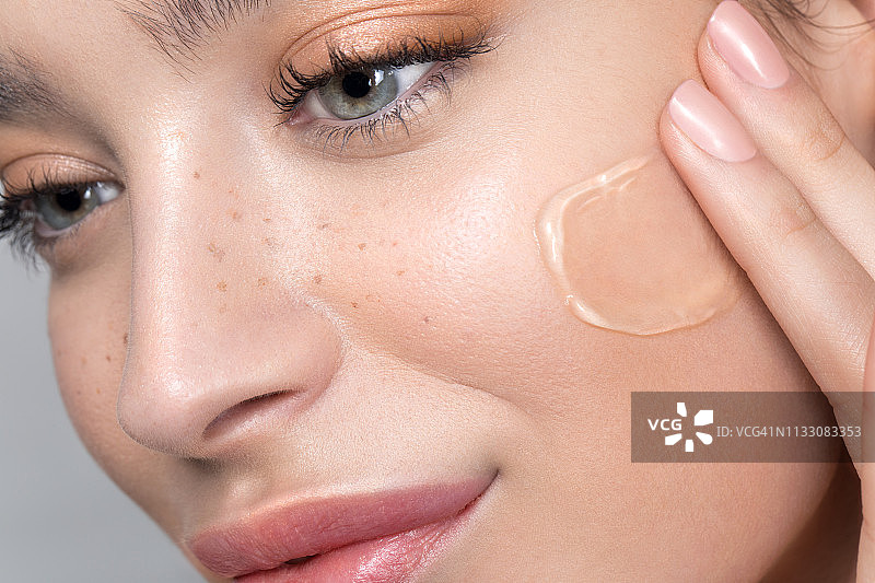 肌肤无瑕的年轻女人正在涂粉底图片素材