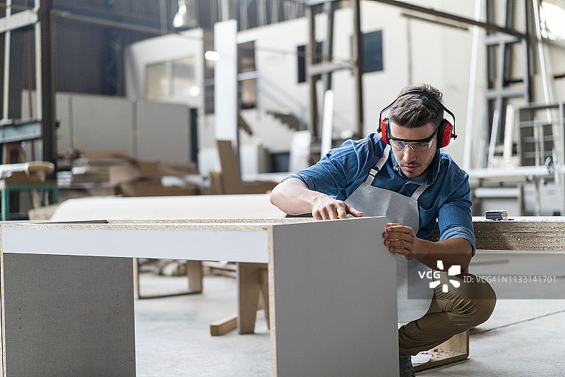 熟练的木匠在车间制作橱柜图片素材