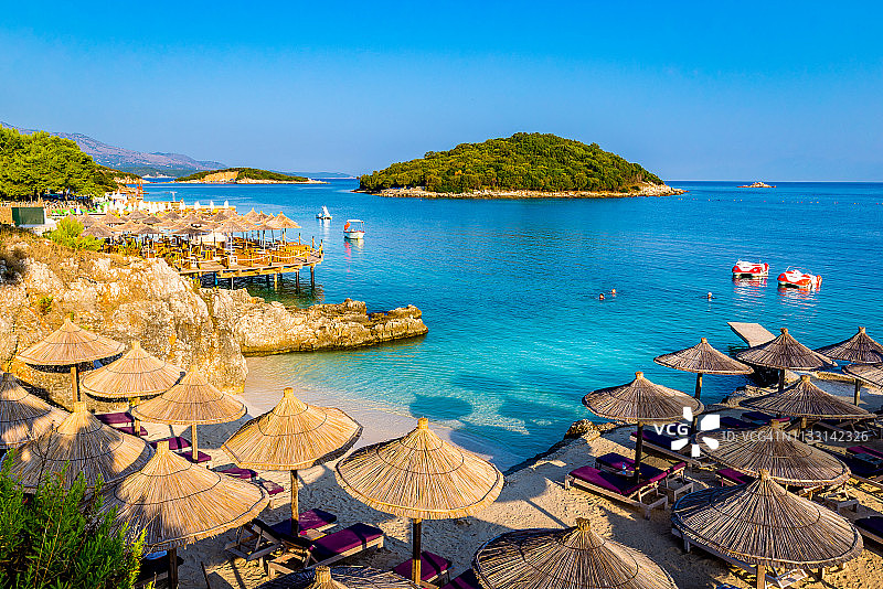 萨米尔海滩的遮阳伞、躺椅和船只，发罗拉，爱奥尼亚海，阿尔巴尼亚图片素材