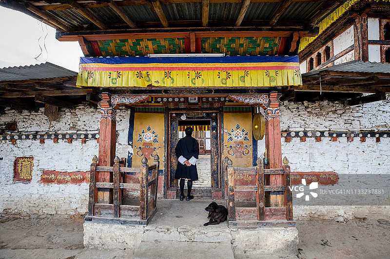 男人在不丹扎卡尔塔姆辛拉康寺庙的入口处图片素材