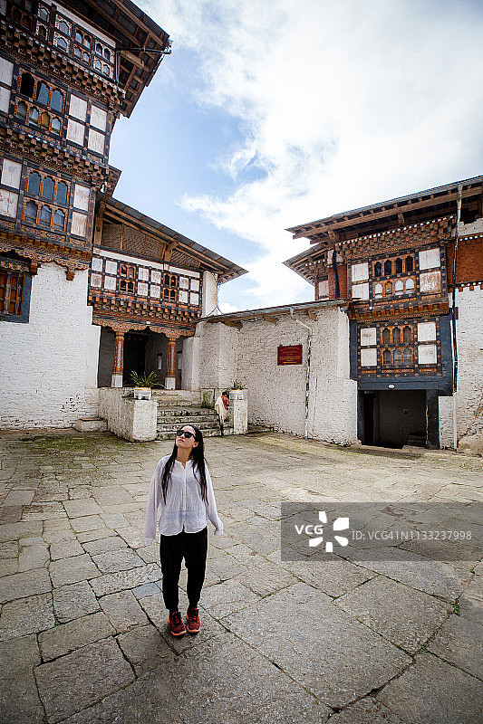 一位年轻女人仰望不丹特朗萨宗图片素材