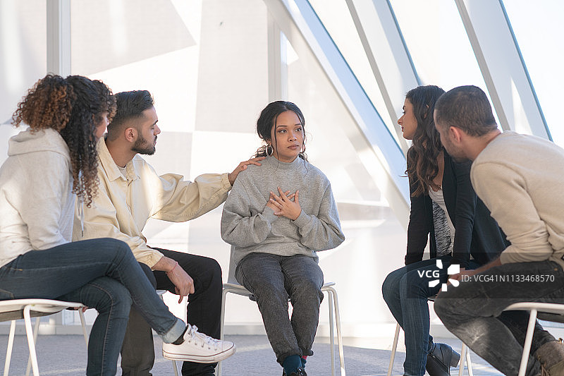 年轻人在团体治疗中安慰朋友图片素材