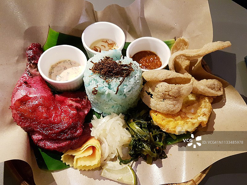 蓝色米饭配唐杜里烤鸡、煎蛋及其他调味品图片素材