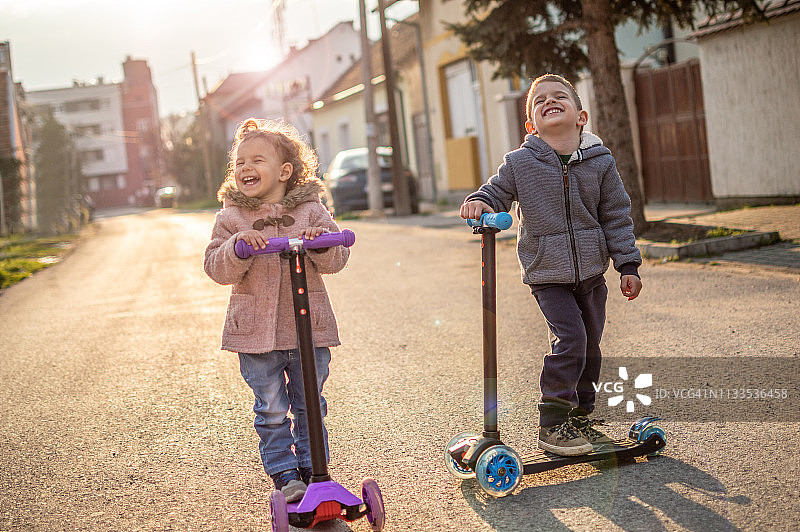 男孩和女孩玩滑板车图片素材