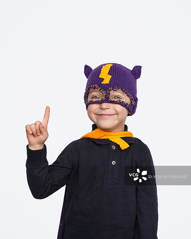 微笑并指向上方的小超级英雄图片素材