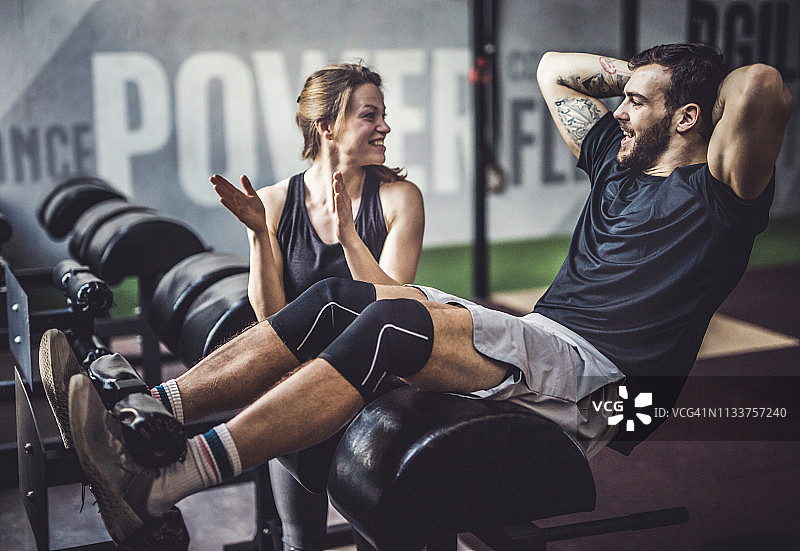 健身房里相互扶持的快乐运动情侣图片素材