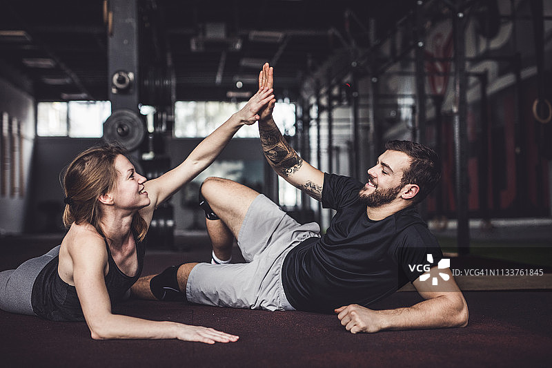 健身房里互相击掌的快乐运动情侣图片素材