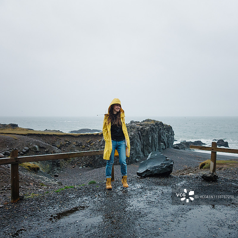 在雨天在海滩上行走的年轻女子图片素材