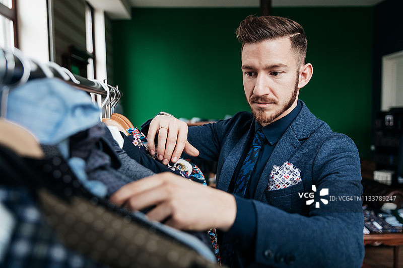 男装店员整理服装架图片素材