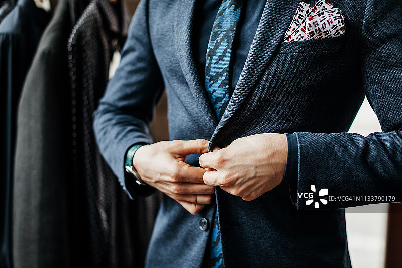 男人扣西装纽扣的特写图片素材