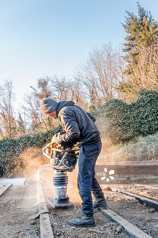 男人使用冲击夯压实土壤图片素材