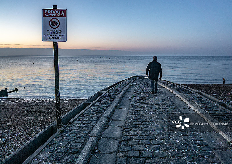 男子走下肯特郡惠特stable的滑道图片素材