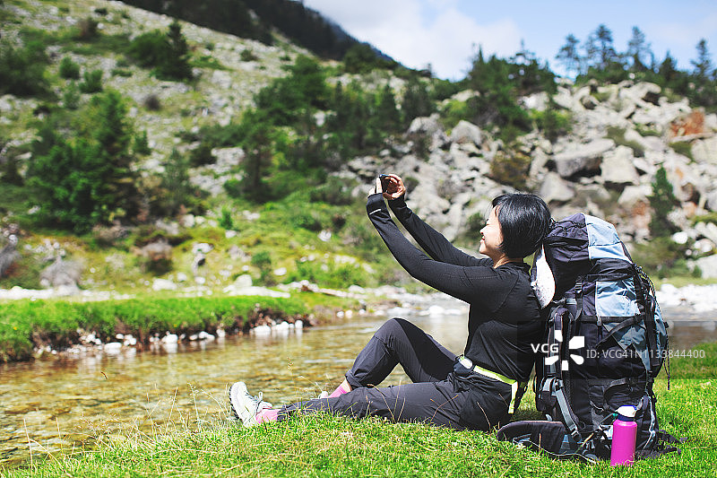 年轻女子在高山上徒步旅行图片素材