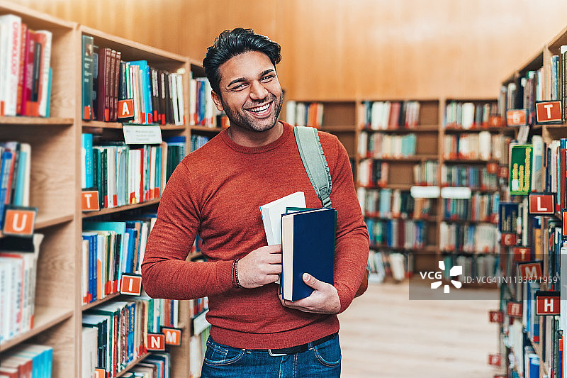 在图书馆里微笑的年轻男人图片素材