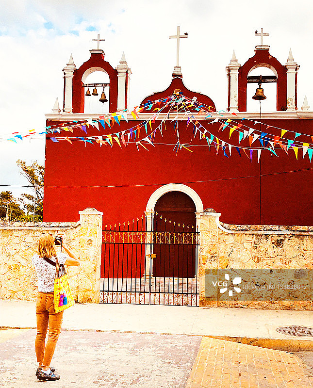 墨西哥尤卡坦：女游客拍摄美丽的红色教堂图片素材