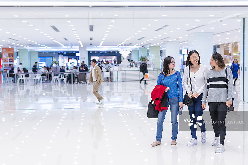一群年轻的亚洲女性在购物中心里走动图片素材