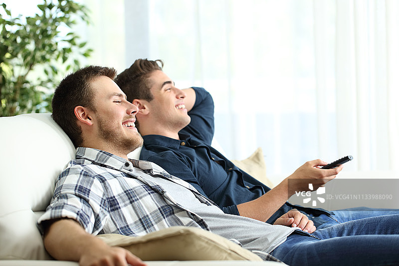 两个朋友在家放松地看电视图片素材