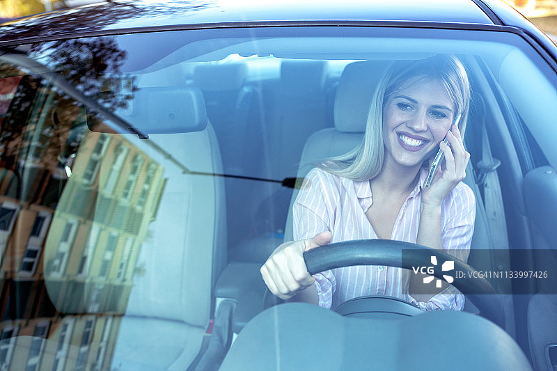 一手拿手机一手握方向盘图片素材