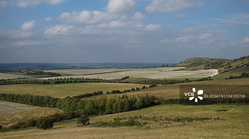 阳光明媚的农田和绵延山丘图片素材