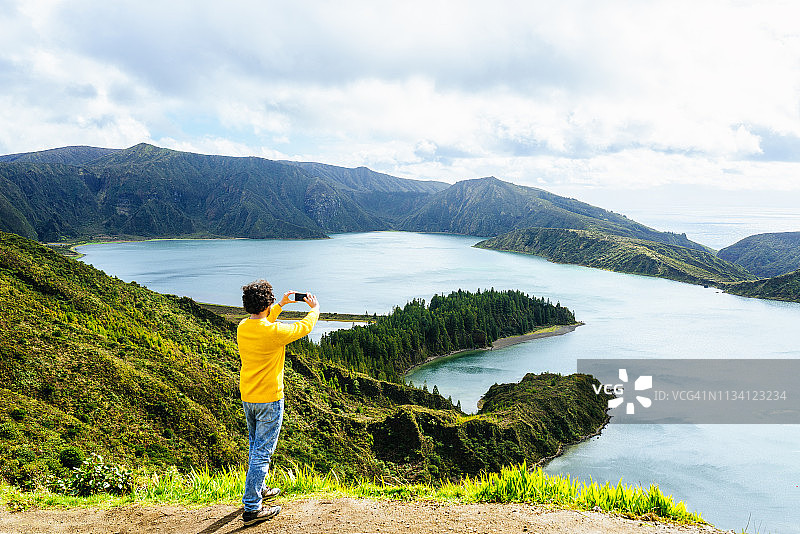 男子在葡萄牙亚速尔群岛圣米格尔岛火湖用手机拍照图片素材