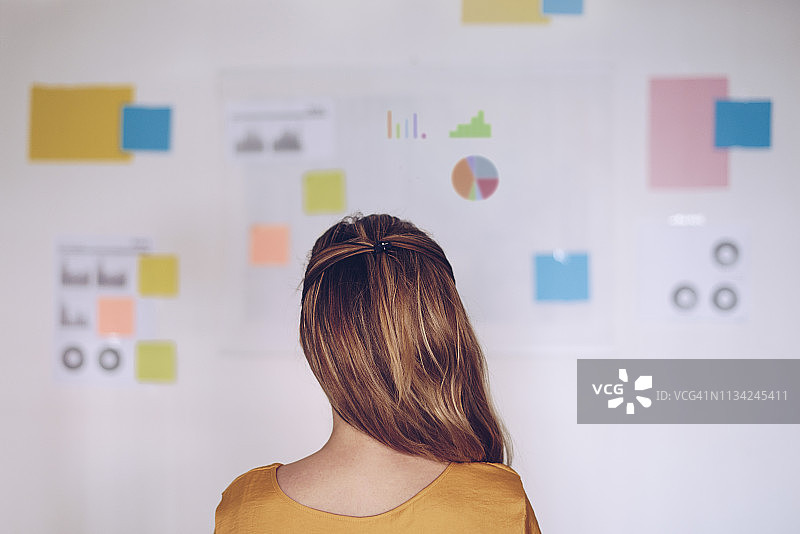 女人站在满是笔记的图表前图片素材