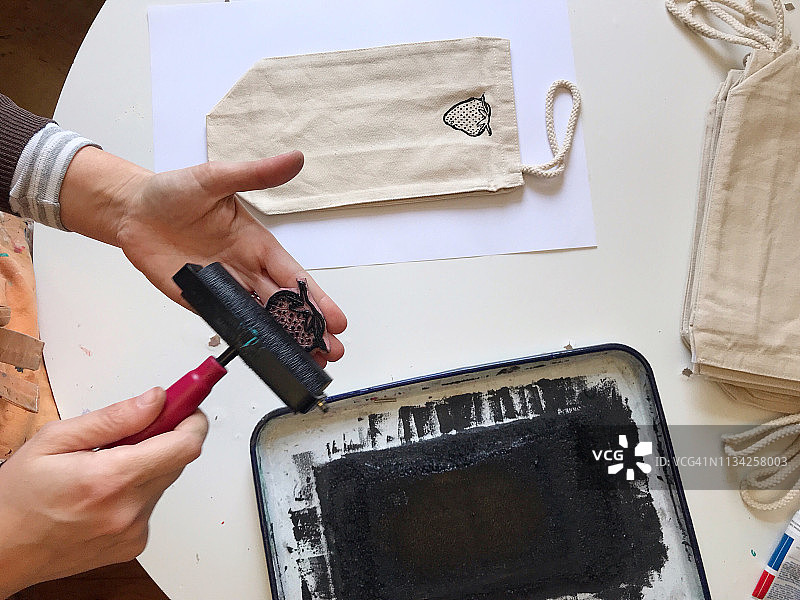 用油毡版画在布袋上印刷的女艺术家图片素材