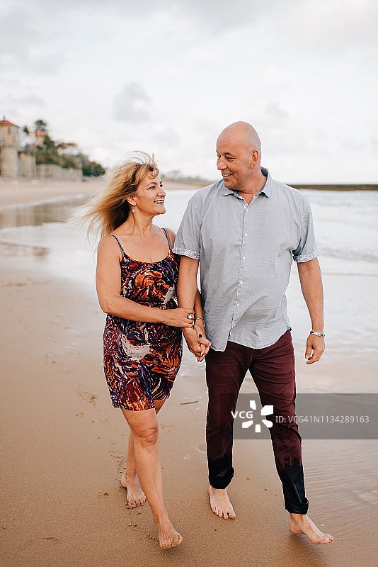 情侣在葡萄牙里斯本埃斯托利尔海滩散步图片素材