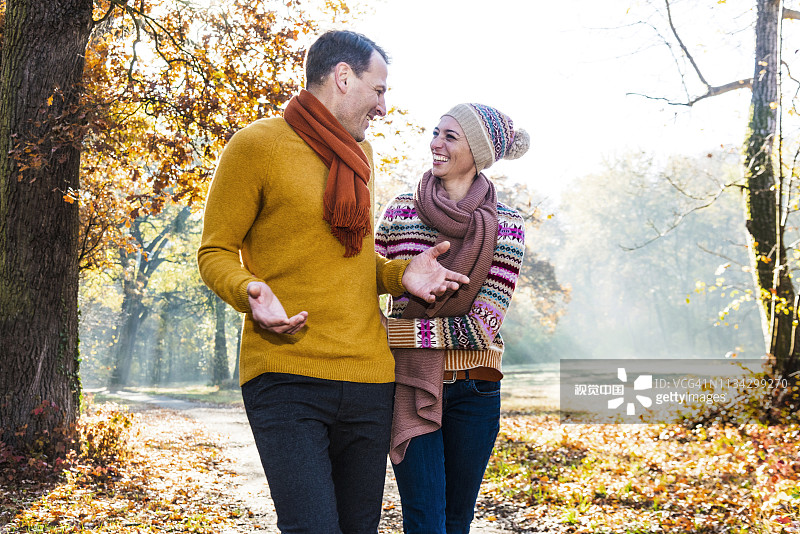 德国曼海姆斯特兰德巴德，一对情侣在秋天的公园里散步图片素材