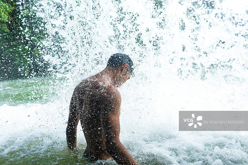 在清爽瀑布下的男人图片素材