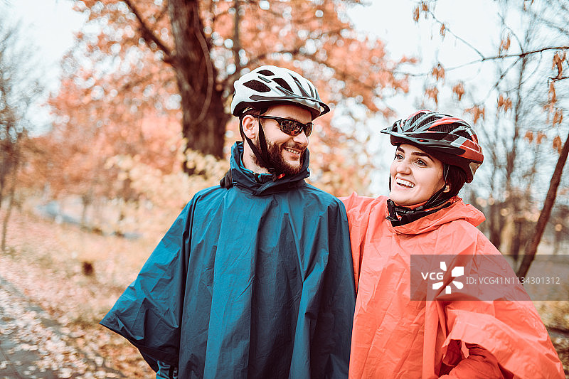情侣在公园欣赏美丽的秋色，享受骑行乐趣图片素材