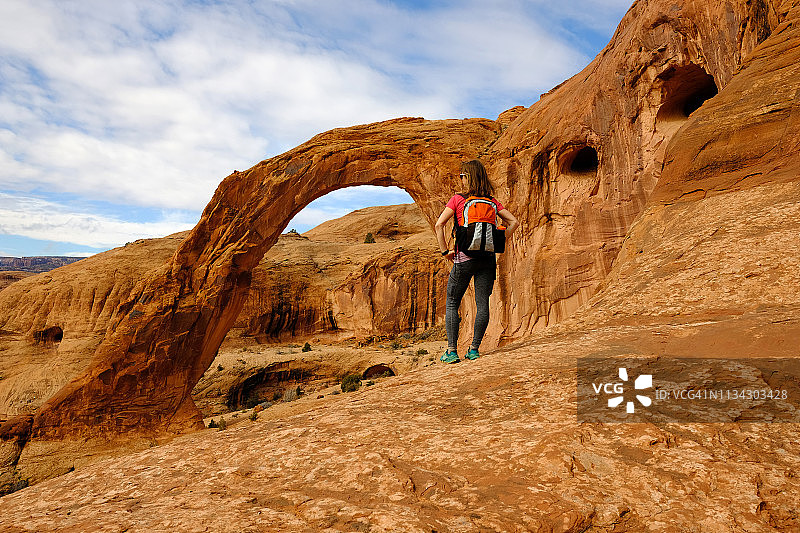 女人在犹他州摩押的科罗娜拱门徒步旅行图片素材
