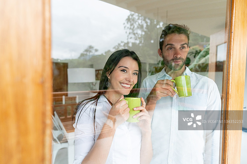情侣在家喝咖啡，一起欣赏窗外景色图片素材