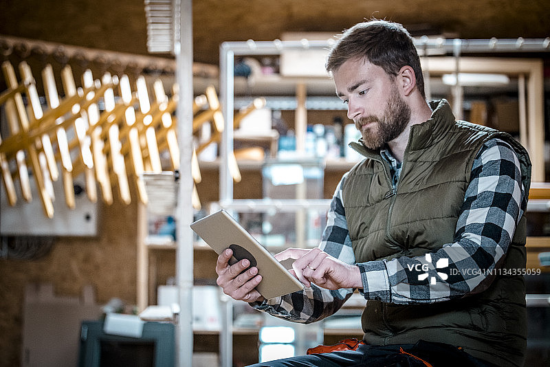 工人在木工车间使用平板电脑图片素材