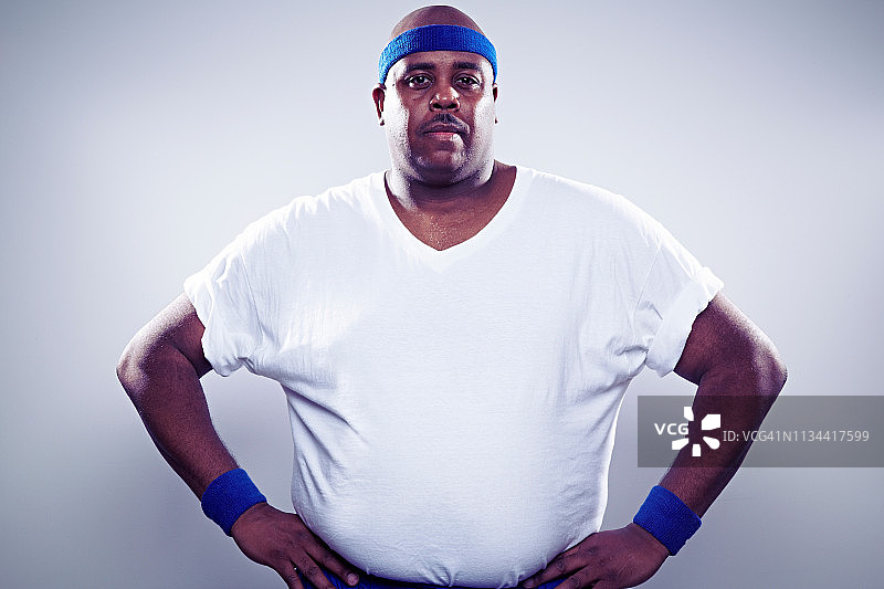 中年男人穿着白色T恤，双手叉腰图片素材